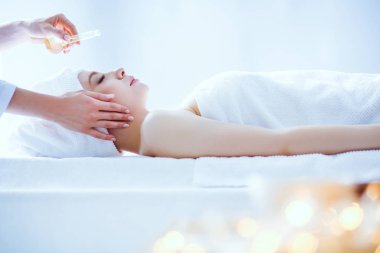 Masaj masasında uzanmış gözleri kapalı rahatlayan genç bir kadın. - Kadın. Spa salonu