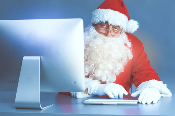 Papai Noel ler cartas de crianças e escrever respostas a eles usando laptop — Fotografia de Stock