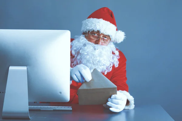 Papai Noel ler cartas de crianças e escrever respostas a eles usando laptop — Fotografia de Stock