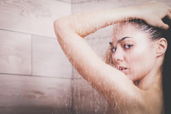Молода жінка під душем у ванній . — стокове фото