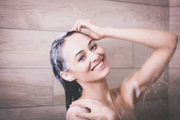 Ung vacker kvinna under dusch i badrum. — Stockfoto