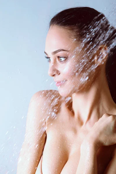 Joven mujer hermosa bajo la ducha en el baño . — Foto de Stock