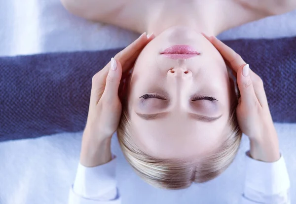 Ung kvinna liggande på ett massagebord, avslappnande med slutna ögon. Kvinnan. Spasalong — Stockfoto