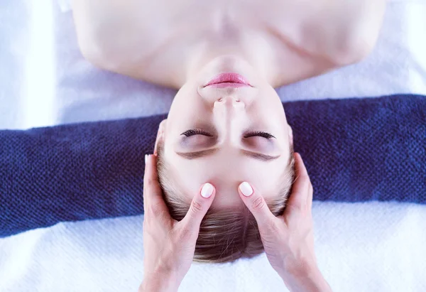 Mujer joven acostada en una mesa de masaje, relajándose con los ojos cerrados. Una mujer. Salón de spa — Foto de Stock