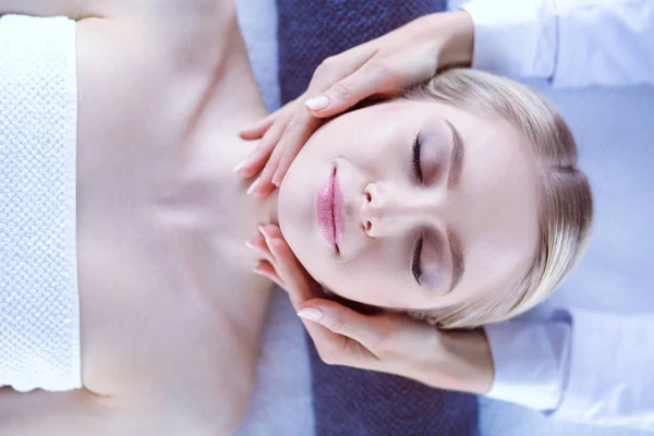 Jeune femme allongée sur une table de massage, relaxante les yeux fermés. Femme. Salon de spa — Photo