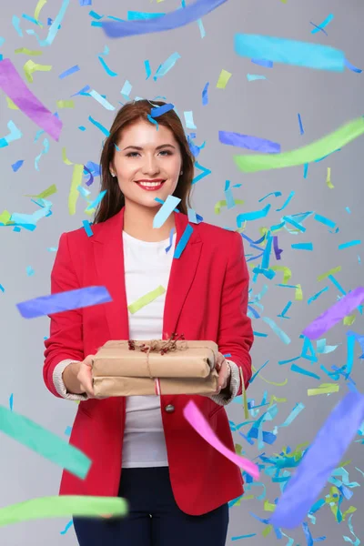 Beautiful happy woman with gift box at celebration party with confetti . Birthday or New Year eve celebrating concept — Stock Photo, Image