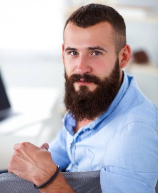 Genç işadamı koltukta oturuyor.