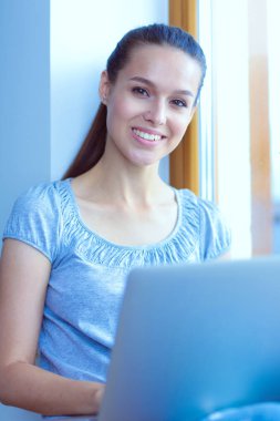 Evde bir dizüstü bilgisayar kullanan genç güzel kadın. Genç güzel kadın.