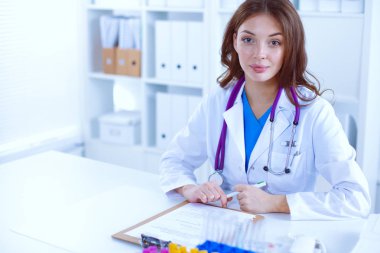 Kadın araştırmacı, beyaz şişeler ve şişelerle çevrili..