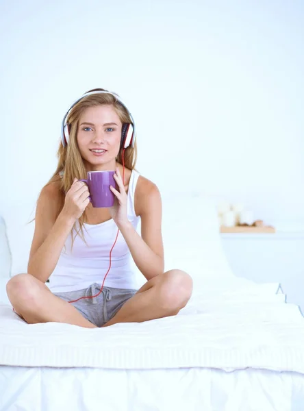 Sabah müzik dinleme yatağa evde oturan güzel kadın portresi. Güzel bir kadın portresi — Stok fotoğraf