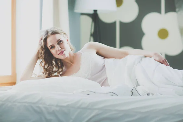 Hübsche Frau legt sich zu Hause auf ihr Bett. — Stockfoto