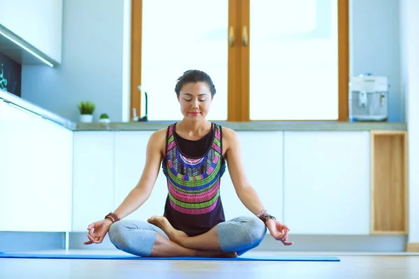 Mujer joven haciendo yoga en casa en la posición de loto. Yoga. Una mujer. Estilo de vida — Foto de Stock