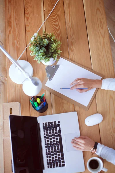 Jonge vrouw werkend zittend aan een bureau. — Stockfoto