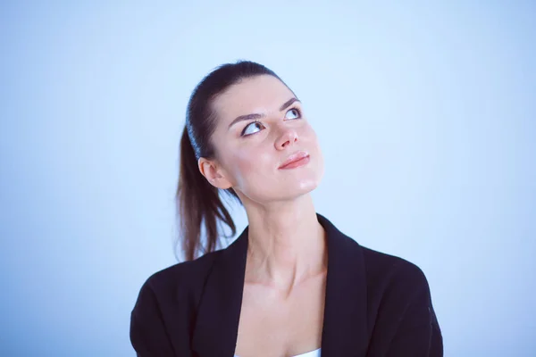 Jonge vrouw permanent, geïsoleerd op grijze achtergrond — Stockfoto