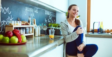 Mutfakta masada oturan genç bir kadın. .