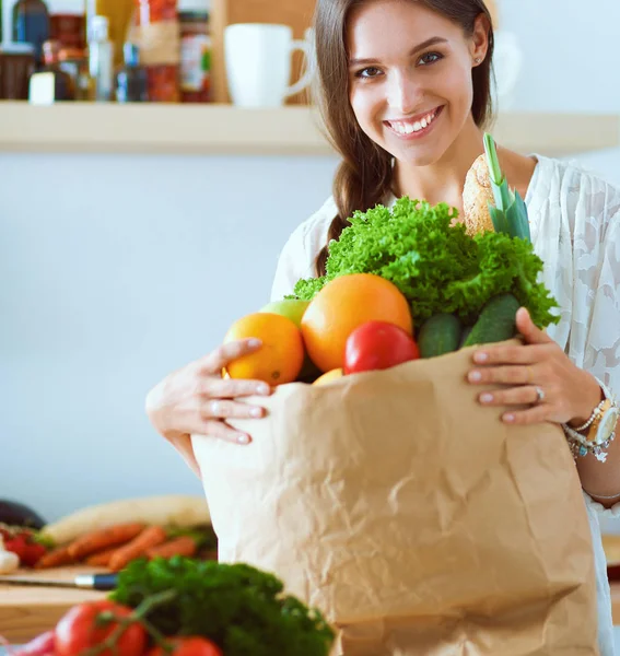 Young woman holding grocery shopping bag with vegetables — Stock Photo, Image