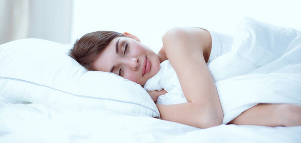 Beautiful girl sleeps in the bedroom, lying on bed