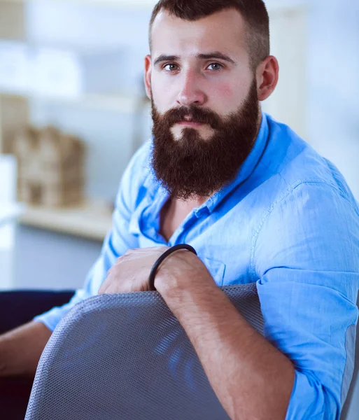 Bello giovane seduto e al lavoro sul computer portatile — Foto Stock