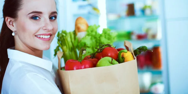 Νεαρή γυναίκα που κρατά τσάντα ψώνια με λαχανικά. — Φωτογραφία Αρχείου