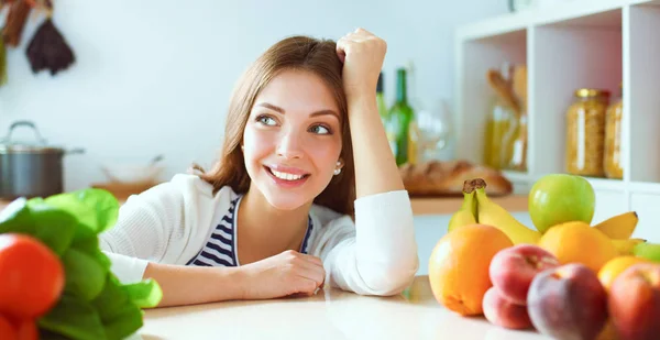 Young woman standing near desk in the kitchen — Stock Photo, Image