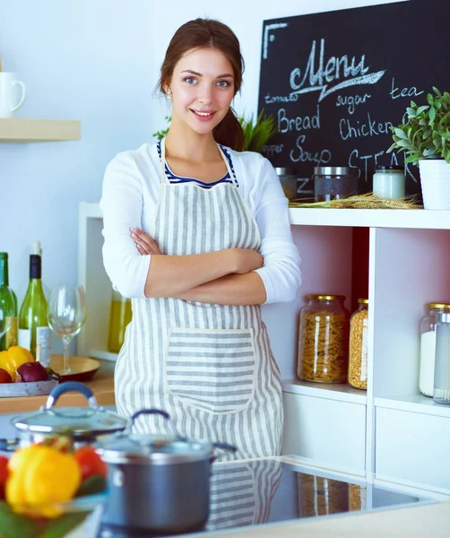 Giovane donna in piedi vicino alla scrivania in cucina — Foto Stock