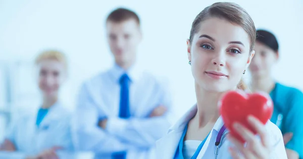 Doctora con estetoscopio sosteniendo el corazón rojo — Foto de Stock