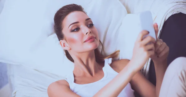 Happy brunette taking a photo of herself with her mobile phone in bedroom — Stock Photo, Image