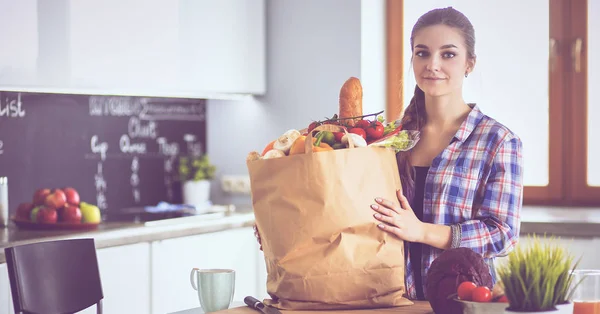 Young woman holding grocery shopping bag with vegetables — Stock Photo, Image