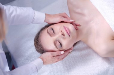 Masaj masasında uzanmış gözleri kapalı rahatlayan genç bir kadın. - Kadın. Spa salonu