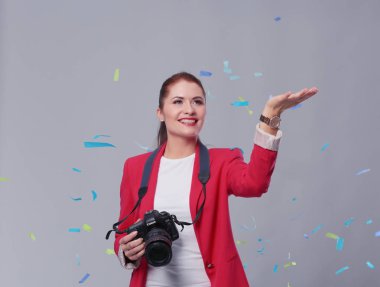 Kamera ile konfeti kutlama partisinde güzel mutlu kadınla. Doğum günü veya yeni yıl arifesi kavramı kutlama