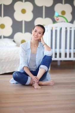 Genç kadın lotus pozisyonunda evde Yoga yapıyor. Genç kadın yoga yaparken.