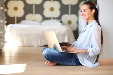 Çocuk karyolası dizüstü bilgisayar ile yakın katta oturan bir genç bayan. Genç anne