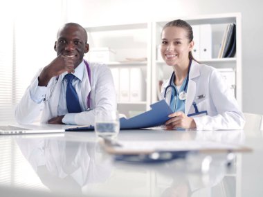 Ofiste tokalaşırken gülümseyen iki genç tıp adamı. Doktorlar. Takım çalışması.