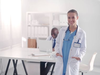 Ofiste tokalaşırken gülümseyen iki genç tıp adamı. Doktorlar. Takım çalışması.