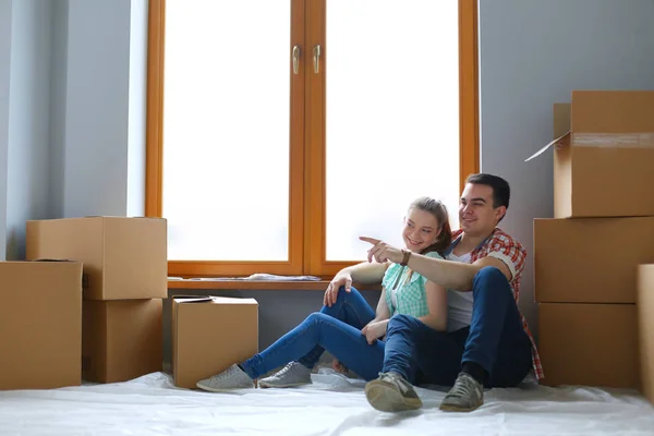 Par som flyttar i huset sitter på golvet. Par — Stockfoto