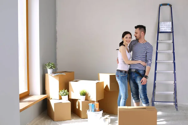 Щаслива молода пара розпаковує або упаковує коробки і переїжджає в новий будинок. молода пара — стокове фото