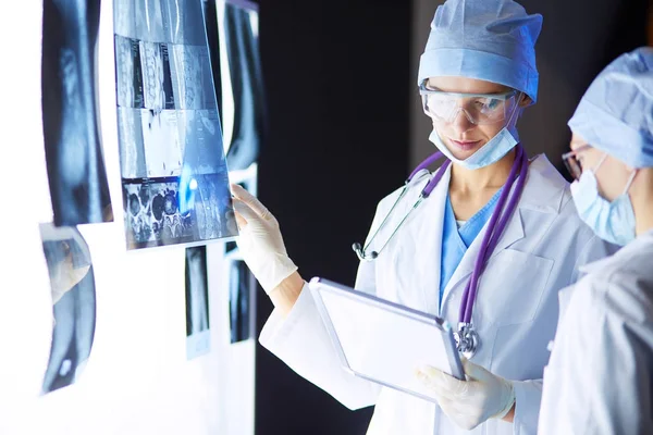 Two female women medical doctors looking at x-rays in a hospital. — Stock Photo, Image