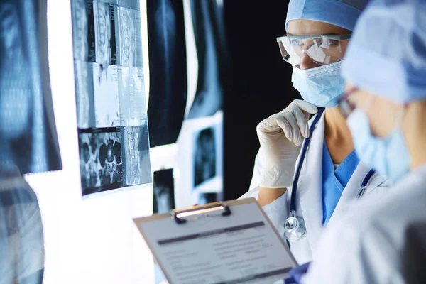 Twee vrouwelijke artsen die röntgenfoto 's bekijken in een ziekenhuis. — Stockfoto