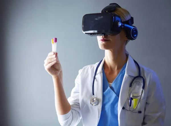 Female doctor wearing virtual reality glasses isolated on white background.