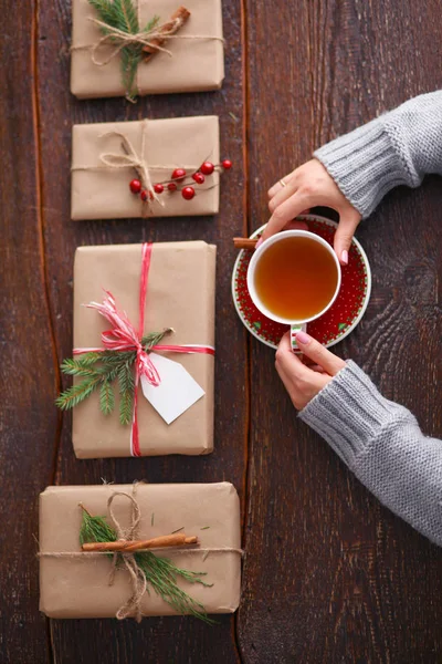 Femme assise sur le bureau avec boîte cadeau de Noël. Mains de femme — Photo