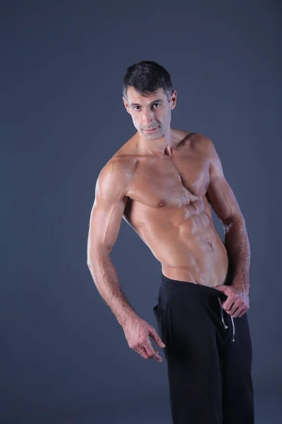 Musclé. Homme musclé sur fond gris montrant des muscles. Professeur de fitness. Professionnel de fitness. Entraînement. Fitness homme . — Photo