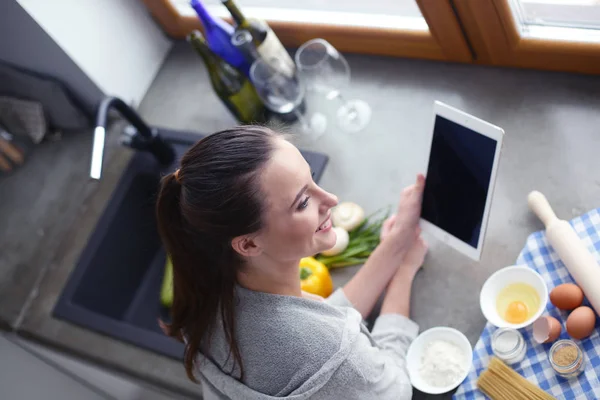 Schöne Frau beim Kuchenbacken in Küche neben Schreibtisch. — Stockfoto