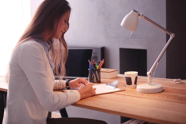 Mujer joven trabajando sentada en un escritorio. Empresaria. Dibujo. Estudiante. Lugar de trabajo. Escritorio. — Foto de Stock