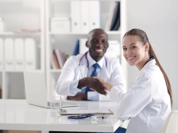 Dois jovens médicos sorridentes felizes a apertar a mão no escritório. Médicos. Trabalho em equipa — Fotografia de Stock