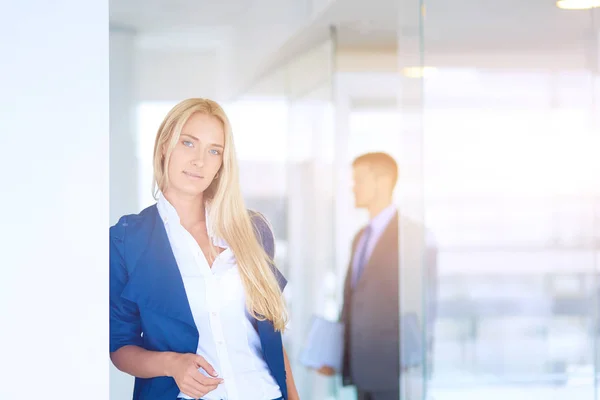 Businesswoman standing against office window talking on mobile phone . Businesswoman — Stock Photo, Image