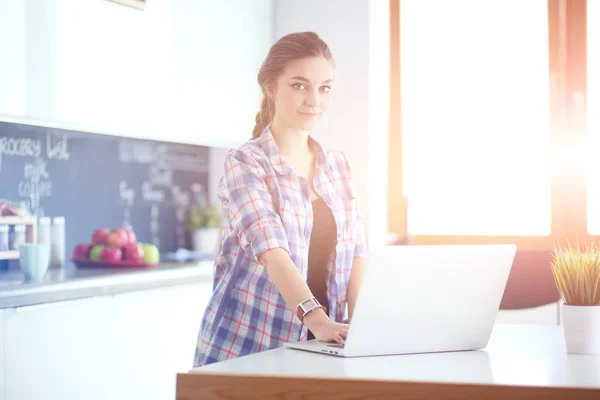 Bella giovane sorridente medico femminile seduto alla scrivania e la scrittura. — Foto Stock