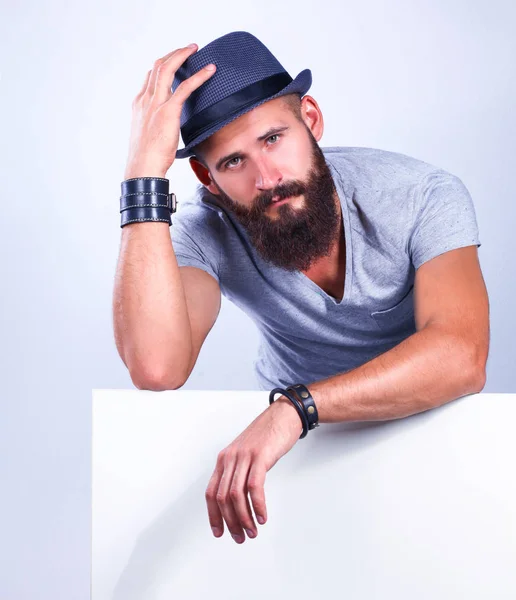 Portrait of young man in hat standing near blank, isolated on white background — Stock Photo, Image