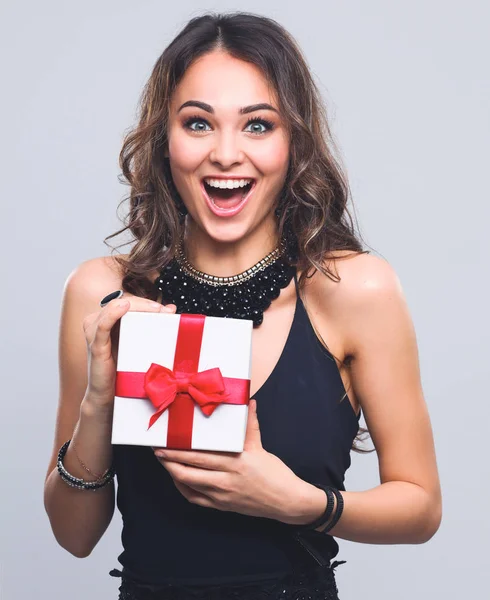 Mujer joven sonrisa feliz celebrar caja de regalo en las manos, aislado sobre fondo gris —  Fotos de Stock