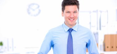 Ofiste masasının karşısında duran bir iş adamı ya da yönetici.