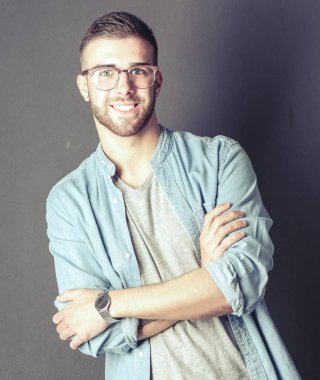 Mutlu bir casual adam ayakta karanlık bir arka plan üzerinde izole portresi
